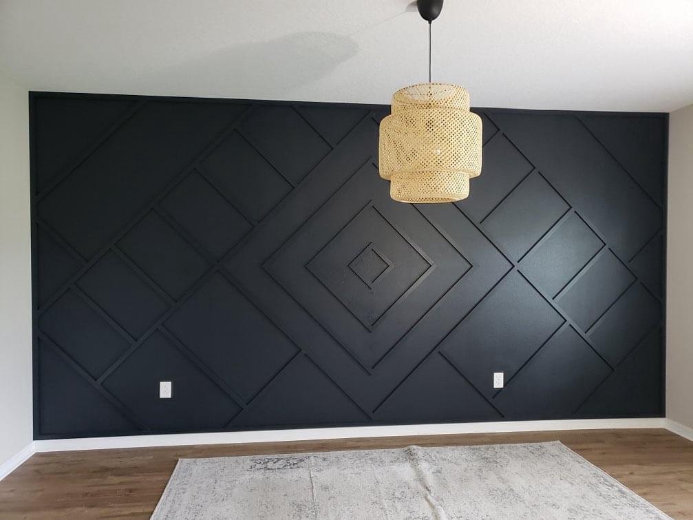 Black geometric accent wall with layered diamond trim pattern